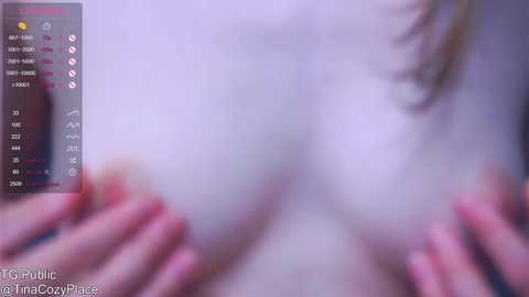 Media: A blurry video shows a close-up of a woman's bare breasts, with her hands covering them, and a side profile of her face visible. The background is indistinct.