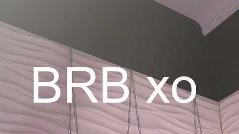 Media: Video of a modern tent ceiling with wavy, light pink fabric panels and a dark gray ceiling. The text \"BBB X0\" is superimposed in white, bold letters.