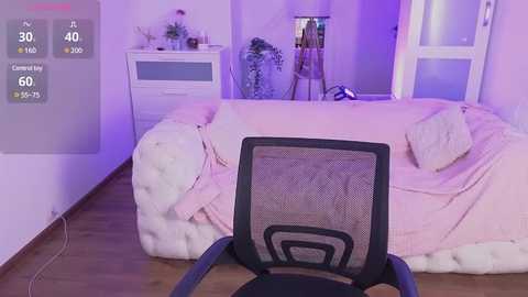 Media: Video of a cozy bedroom with a tufted white bed, light pink bedding, and a blue office chair facing the bed. Purple ambient lighting.