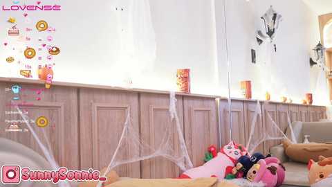 Media: Video of a playful, Halloween-themed living room with spider webs, candy boxes, plush toys, and a large mirror reflecting festive decor.