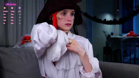 Media: A video of a young woman in a period costume, adjusting her red wig, with a gaming overlay in the top left corner.