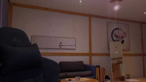 Media: Video of a minimalist living room with a dark blue couch, wooden paneling, a large mirror, and a framed abstract painting on a beige wall.