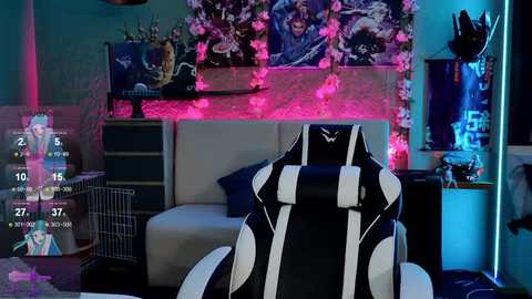 Media: Video of a modern gaming room with a black and white gaming chair, blue and pink LED strip lighting, posters, and a white sofa.