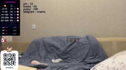 Media: A blurred video of a person in bed with a blue blanket, showing a phone screen with a user's profile and chat. The room has beige walls and a bed with a patterned pillow.