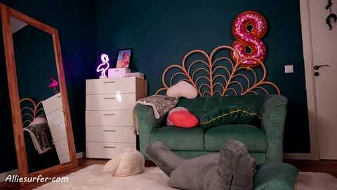 Media: Video of a whimsical, teal-themed children's room with a plush green couch, wooden headboard, neon sign, and elephant-shaped pillows.