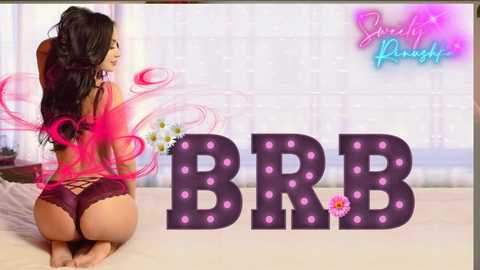 Media: Video of a curvaceous woman with long dark hair kneeling on a bed, wearing maroon lace lingerie. \"BBB\" in large, glowing letters. Background features a white, textured wall and a pink floral motif.