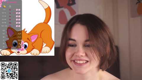 Media: Video of a smiling, light-skinned woman with shoulder-length brown hair, wearing a yellow top. To the left, a digital drawing of an orange cat with blue eyes and a pink flower on its face.