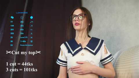 Media: A video of a young woman with pale skin and glasses, wearing a torn sailor schoolgirl uniform, in a dimly lit room. Text overlays indicate \"Cut my top,\" \"44kts,\" and \"3 cats = 10kts.\