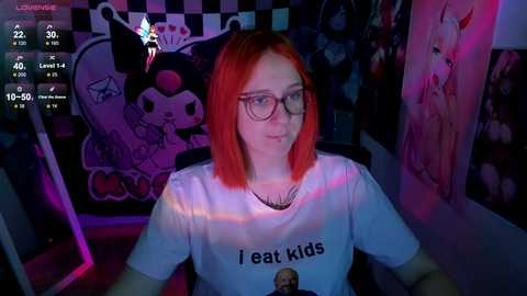 Media: Video of a pale-skinned woman with shoulder-length red hair, wearing glasses and a \"I eat kids\" T-shirt, sitting in a dimly-lit room with anime posters on the wall.