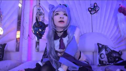 Media: A video of a young woman with pale skin, long silver hair, and cat ears, holding a dildo, in a room with white curtains and neon lights, wearing a black and white outfit.