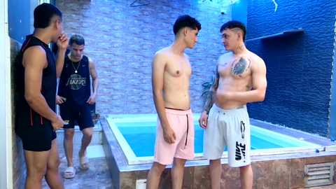 Media: Video of four shirtless men in swimwear, two facing off in a small, blue-tiled pool area with brick walls and a blue-painted surface.