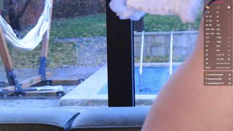 Media: Video of a person in a bathtub, viewed from the side. A white hand towel hangs from a hook, and a blue pool is visible through a window.