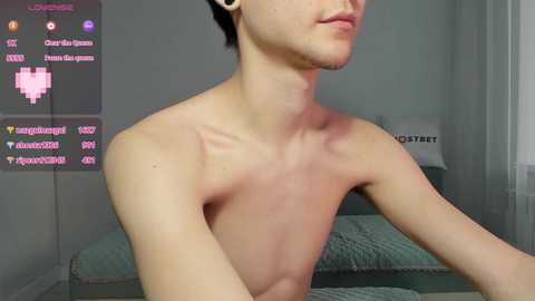 Media: Video of a shirtless, slender, light-skinned man with short dark hair, showing reddish marks on his neck, standing in a dimly lit room with a bed and streaming overlay.