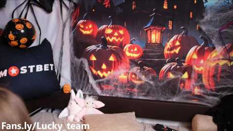 Media: Video of a Halloween-themed room with a large, detailed jack-o'-lantern mural, a black STBET tote bag, and a plush bat.