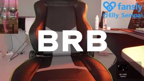 Media: Video of a gaming chair with adjustable armrests, displaying a \"BRB\" message in bold white text. The room features a desk with a keyboard, mouse, and monitor. Background includes a white wall and a fan logo.