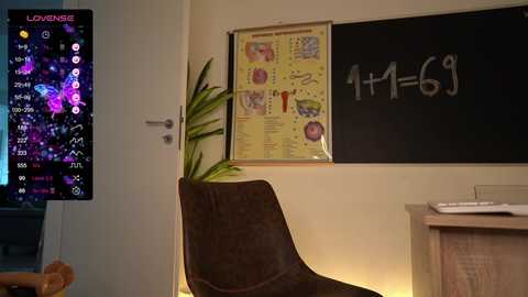 Media: Video of a cozy, dimly-lit room with a large, brown armchair, a potted plant, a colorful anatomy poster, and a chalkboard with equations.