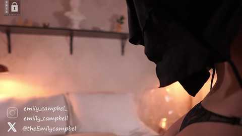 Media: Video of a person with a black mask and a black towel on their head, in a dimly lit bathroom, with a warm, glowing candle in the background.