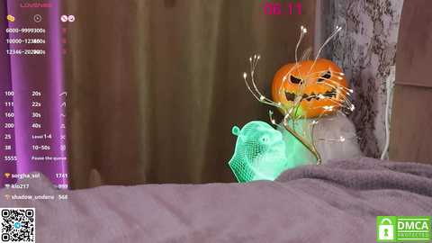 Media: A video of a realistic pumpkin with a face, placed on a bed, surrounded by a green plastic bag, taken with a smartphone.