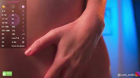 Media: Video of a close-up of a light-skinned, nude hand with manicured nails, covering the genital area, with a blue and orange background.