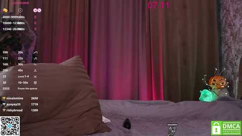 Media: Video of a bedroom with a brown bed, a large plush toy, and a small green robot figure. The room has a dim, pinkish-purple light. A \"DMCA NOTICE\" watermark is present.