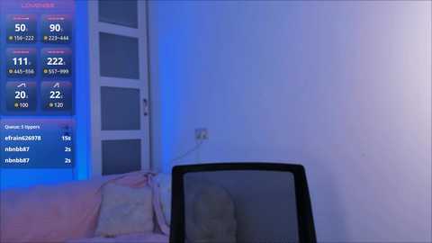 Media: A video of a dimly lit room with a white wall, a black computer monitor, and a digital clock displaying \"20:32\" in blue numbers. A window with a partially open white curtain is visible, with blue LED lighting creating a cool ambiance.