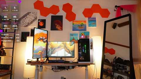 Media: Video of a modern, colorful room with hexagonal orange wall art, a desk holding a computer, a large monitor, and a standing lamp, along with various art pieces and a shelf with books.