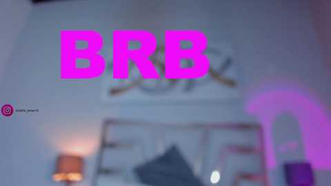 Media: A video of a bedroom with a large, neon pink \"BBR\" sign on the wall. The room features a white bed with a pillow and a lamp on a nightstand.