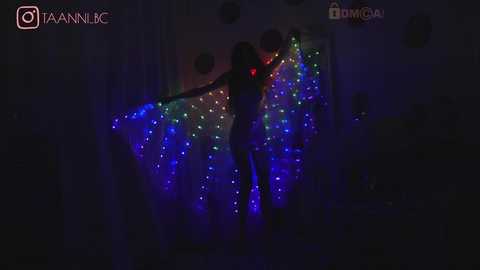 Media: A video of a silhouette figure with red glowing eyes against a backdrop of colorful LED lights, in a dimly lit room with a social media watermark.