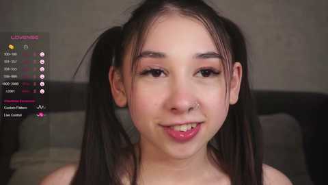 Media: Video of a young Asian woman with fair skin, pigtails, and a nose ring, smiling. Background shows streaming platform controls.