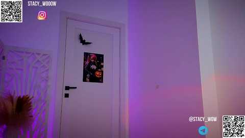 Media: Video of a white door with a Halloween-themed poster, purple and pink lighting, QR codes in top corners, and a potted plant in the left foreground.