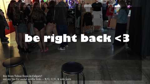 Media: Video of a crowded, dimly lit nightclub with people in casual attire, including a person sitting on a stool. Text overlay reads, \"be right back <3.\