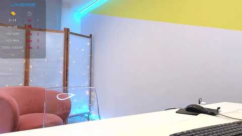 Media: A video of a modern, minimalist office reception area featuring a red sofa, glass partition, and a white desk with a black mouse. The walls are painted white with a yellow stripe, and blue LED lights provide ambient lighting.