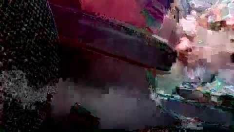 Media: Video of a chaotic crowd scene, likely a protest, featuring a multitude of people in various states of distress, with intense, blurred colors of red, pink, and purple dominating the background.