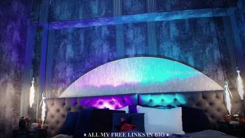 Media: Video of a modern bedroom with a dark, tufted headboard, blue and purple accent lighting, and a textured, industrial-style wall.