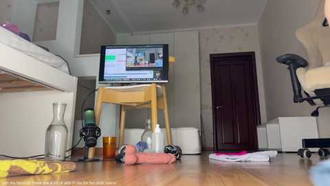 Media: Video of a cluttered bedroom with a wooden desk, computer monitor displaying a website, and scattered items on the floor.