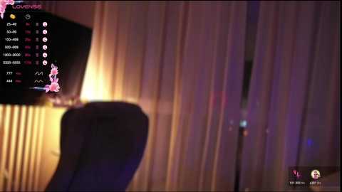 Media: Video of a dimly-lit room with a flat-screen TV displaying a streaming platform interface. The background features sheer curtains, and the room is softly illuminated.