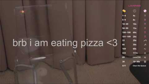 Media: A video of a brown couch with a clear glass on it, overlaid with a text overlay saying \"brib i am eating pizza\" and a heart emoji.