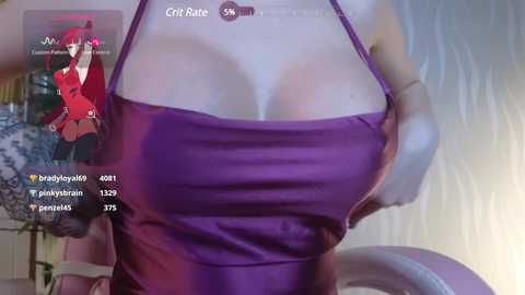 Media: Video of a busty woman in a revealing purple tank top, with a red-haired anime character overlaid on the left.