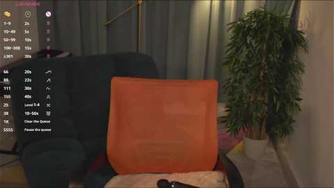 Media: A video of a dimly lit living room with a green sofa, an orange chair, and a tall plant in the background. A virtual reality headset is on a coffee table.