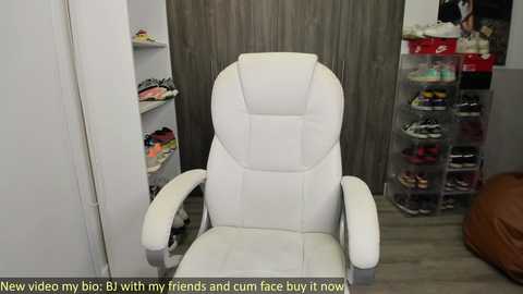 Media: Video of a modern, white leather recliner chair in a brightly lit room, featuring a wall of colorful shoes and a shelf of neatly organized footwear. Text overlays read: \"New video of my big butt with my friends and cum buy it now.\