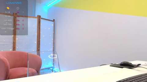 Media: Video of a modern office space with a pink chair, glass partition, blue light accents, yellow wall, and a desk with a mouse.