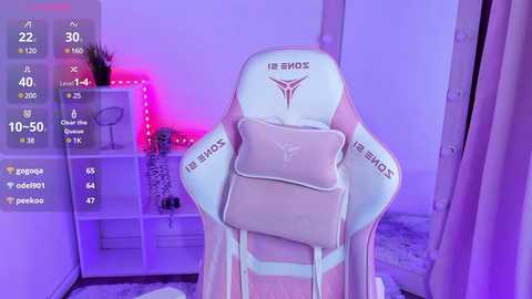 Media: Video of a gaming chair with \"Razer\" logo, pink lighting, white shelves with plants, and a digital overlay showing stats.