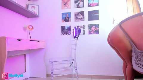 Media: Video of a light-skinned woman wearing a thong, standing in a modern bedroom with a white wall, framed photos, and a transparent clothes rack.