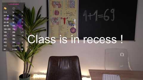 Media: Video of a classroom with a blackboard, a desk, a chair, a plant, and a digital clock. Text overlay reads, \"Class is in recess!\