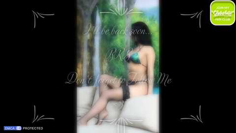 Media: A blurred video of a woman in black lingerie sitting on a beige couch, with a green text overlay and a \"DAMAC\" watermark.