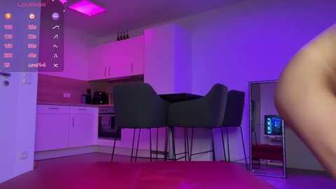 Media: Video of a modern, dimly lit kitchen with purple lighting, featuring a white countertop, dark bar stools, and a mirror reflecting the scene.