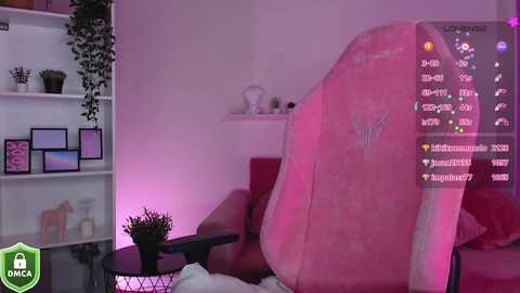 Media: A video of a cozy, pink-themed living room with a large gaming chair, a potted plant, and a pink wall; streaming overlay showing chat and stats.