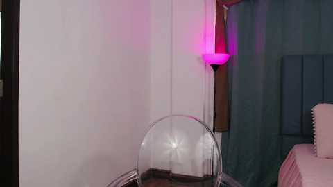 Media: A video of a minimalist room with white walls, a clear acrylic chair, a purple light, and a dark blue curtain.