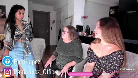 Media: Video of a modern living room with three women, one in a patterned shirt, another in a floral top, and a third in glasses.