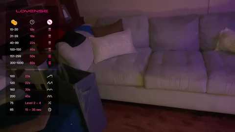 Media: Video of a cozy living room with a white couch, purple lighting, and a \"Lovense\" control panel on the left.